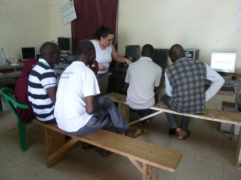 Personnes assises sur des bancs dans une salle d'informatique